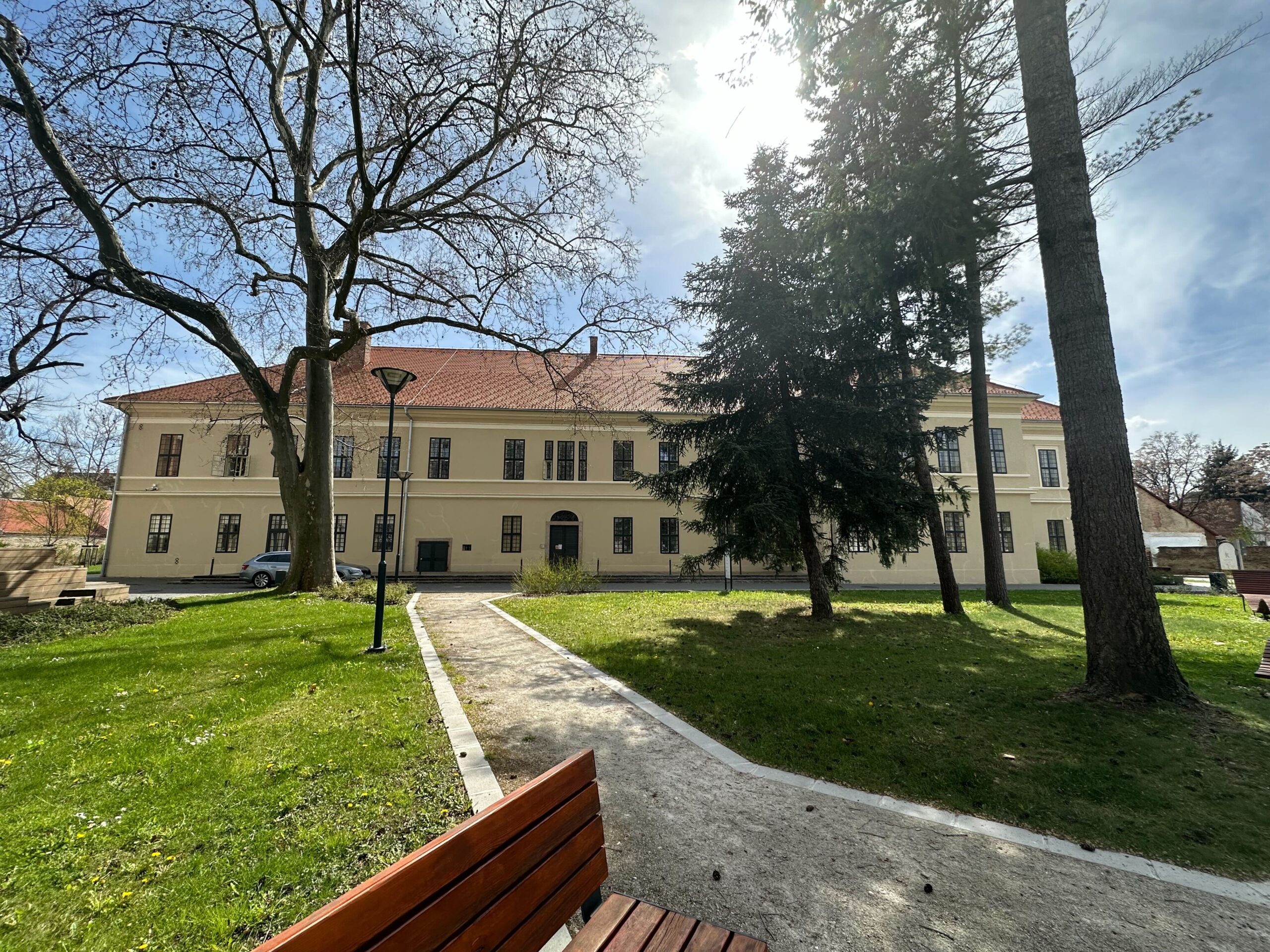 An old-style renovated hous in a park with big trees.
