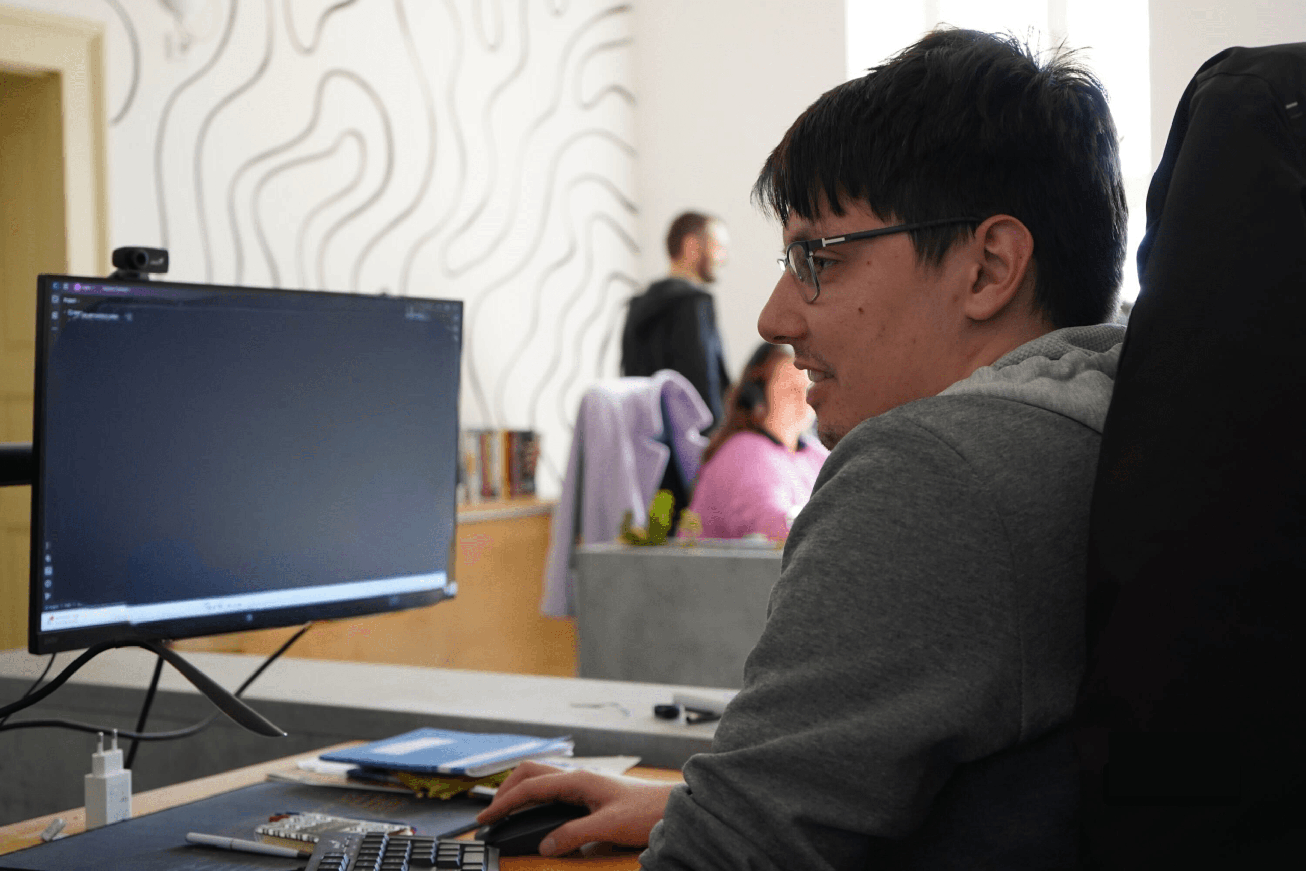 Kollégánk a monitor előtt dolgozik.